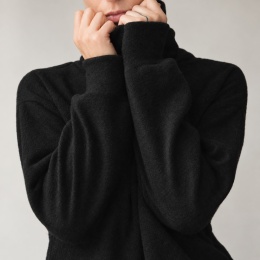 Czarny sweter damski oversize z wysokim golfem i bufkami przy nadgarstkach zbliżenie
